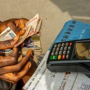 A customer carrying out a transaction at a point-of-sale terminal operated by a PoS agent in Nigeria.