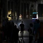 People walking through darkened streets in Havana during widespread blackout as Cuba faces severe fuel shortages.