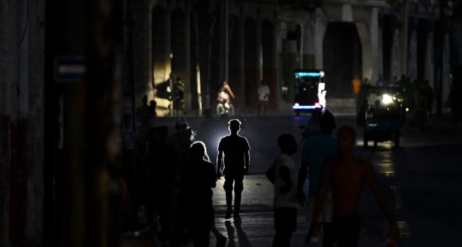 People walking through darkened streets in Havana during widespread blackout as Cuba faces severe fuel shortages.