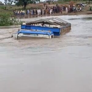 Floodwater covering the collapsed Moro Bridge in Kwara State with stranded vehicles and commuters waiting for rescue.