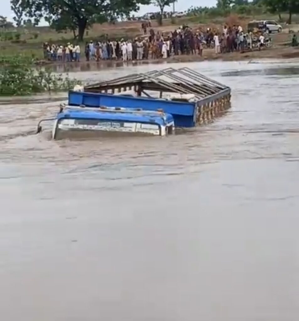 Floodwater covering the collapsed Moro Bridge in Kwara State with stranded vehicles and commuters waiting for rescue.