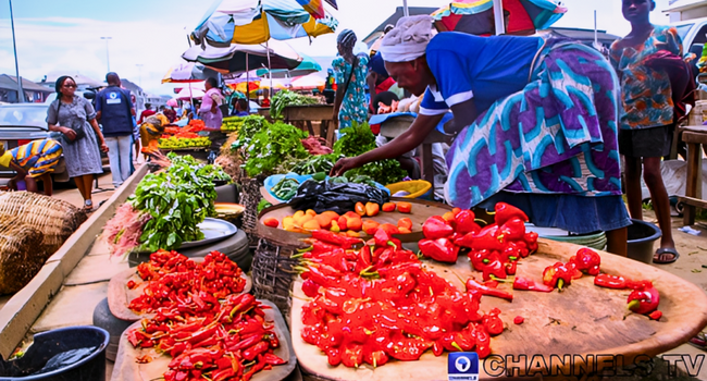 Market traders display tomatoes, beans and other food items in a Nigerian market as inflation rises in April 2026.