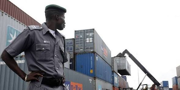 Nigeria Customs Service officials display seized military camouflage uniforms and illicit drugs intercepted from a luxury passenger bus in Ogun State.