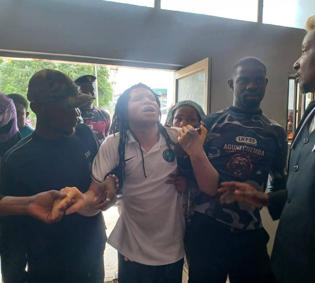 Ikechukwu Ezenagu, popularly known as Muomiri Afuluanya, being assisted by security operatives as he appears before an Anambra State High Court in Awka.