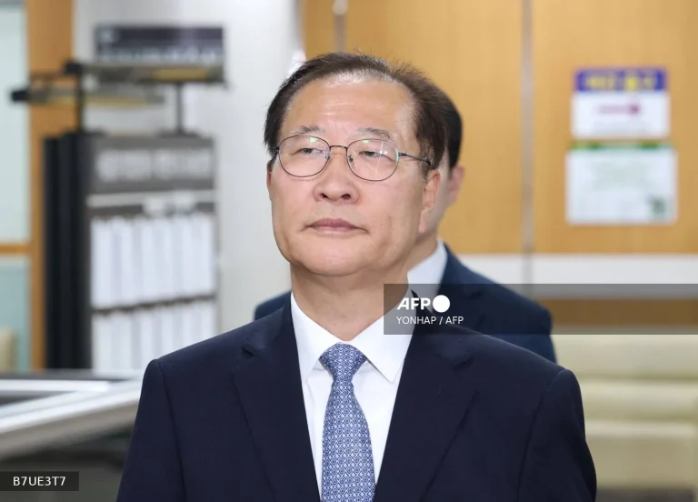 Former South Korean justice minister escorted after sentencing outside Seoul court following 2024 martial law-related conviction.