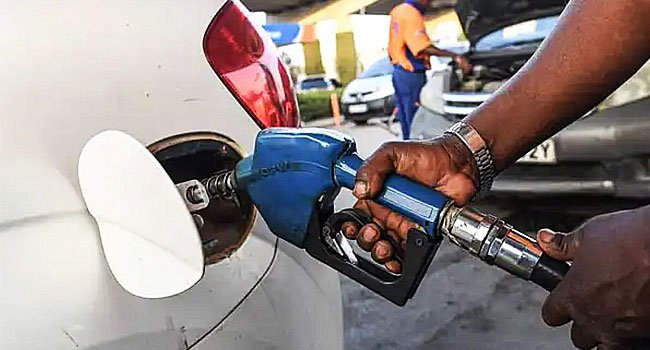 Fuel attendant dispensing petrol into a vehicle at a filling station in Nigeria as PETROAN calls for lower fuel prices following a decline in global crude oil prices.