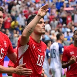 Switzerland players celebrating during a 4-1 World Cup Group B victory over Bosnia and Herzegovina at SoFi Stadium, with Granit Xhaka involved in the match action.