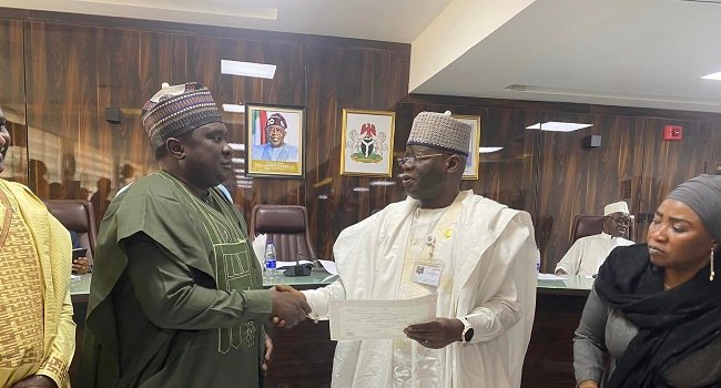 INEC officials presenting Certificates of Return to winners of by-elections held across six Nigerian states during a formal ceremony.