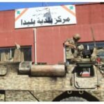 Lebanese soldier sits atop a military vehicle outside a municipal building in Blida, southern Lebanon, following clashes amid the Israel-Hezbollah conflict and ceasefire announcement.