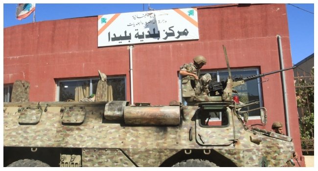 Lebanese soldier sits atop a military vehicle outside a municipal building in Blida, southern Lebanon, following clashes amid the Israel-Hezbollah conflict and ceasefire announcement.