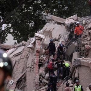 Rescue workers search through the rubble of a collapsed building in Caracas after twin earthquakes struck Venezuela, killing dozens and injuring hundreds.