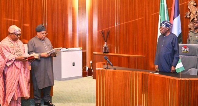 President Bola Tinubu administering oath of office to Joseph Tegbe and Sola Enikanolaiye at the Presidential Villa in Abuja during ministerial swearing-in ceremony.