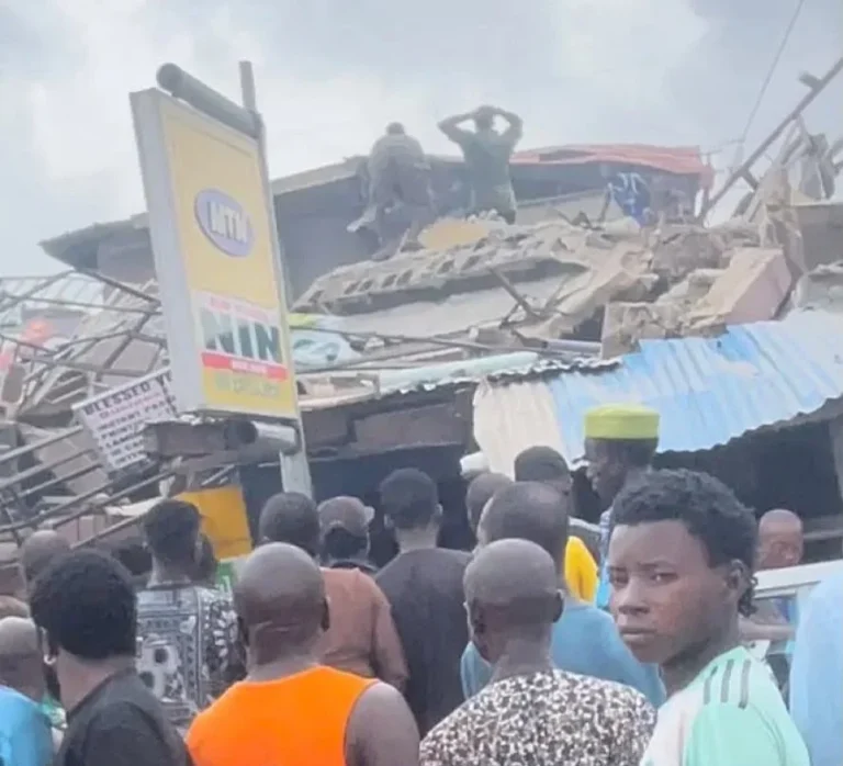 Rescue workers and residents gather around the rubble of a collapsed three-storey building in the Alakija area of Lagos as several people are feared trapped beneath the debris.