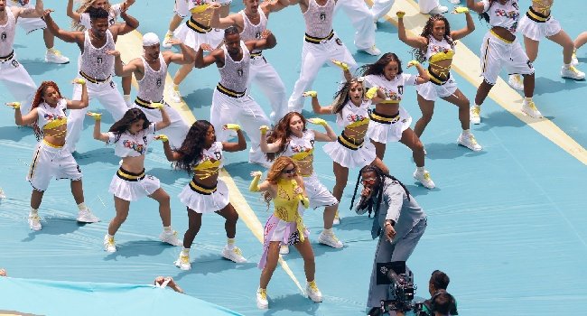 Shakira performing on stage during the 2026 World Cup opening ceremony at Estadio Azteca alongside Burna Boy as fireworks light up the stadium.