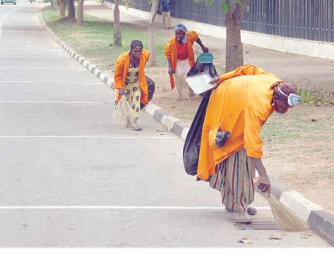 Street sweepers working along a roadside during sanitation exercise in Taraba State, Nigeria.