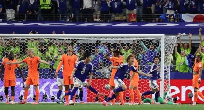 Japan players celebrating a late equaliser against the Netherlands during a 2-2 World Cup Group F match in Texas stadium.