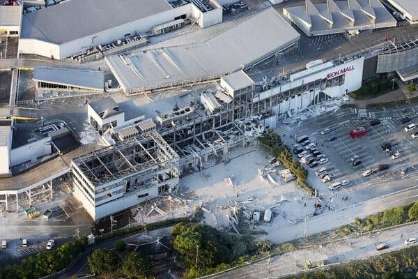 Emergency responders gather outside the damaged Aeon Mall in Kumamoto after a powerful earthquake caused part of the building to collapse.