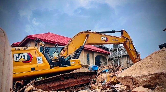 Rescue workers search the rubble after a two-storey building sank into the ground in Ajuwon, Ogun State, killing three people and rescuing 12 others.