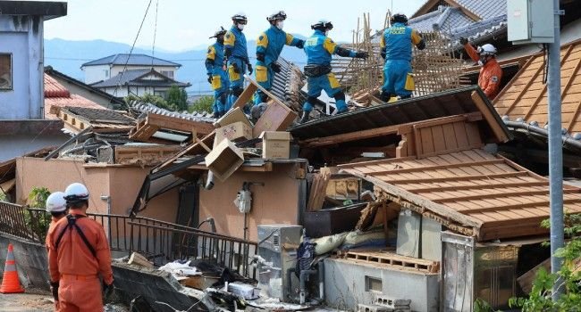 Rescue workers search through the collapsed Aeon shopping mall in Kumamoto after a powerful earthquake as emergency operations continue.