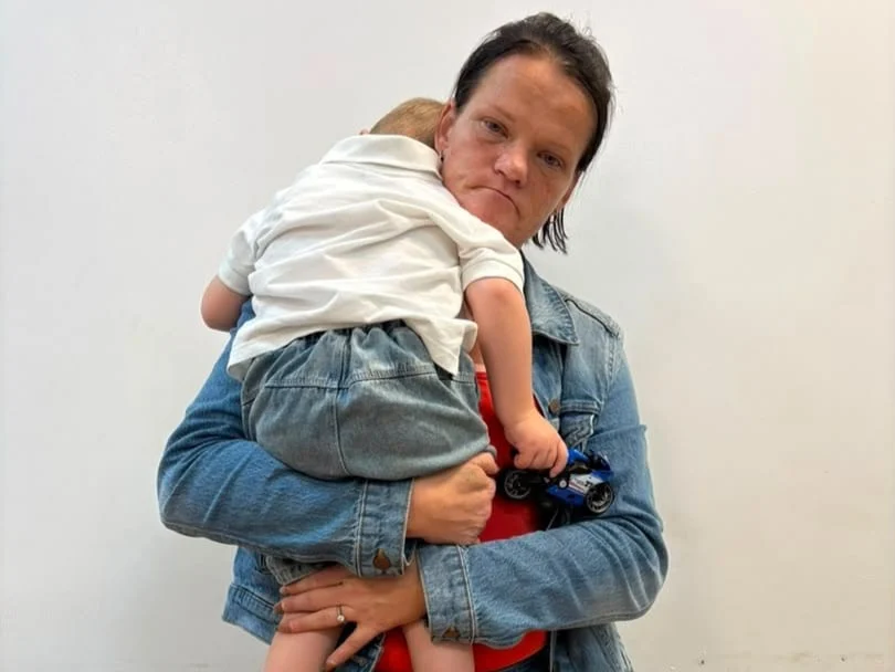NDLEA operatives escort a South African woman arrested at Abuja airport over the alleged smuggling of 5.75kg of heroin while travelling with her young son.