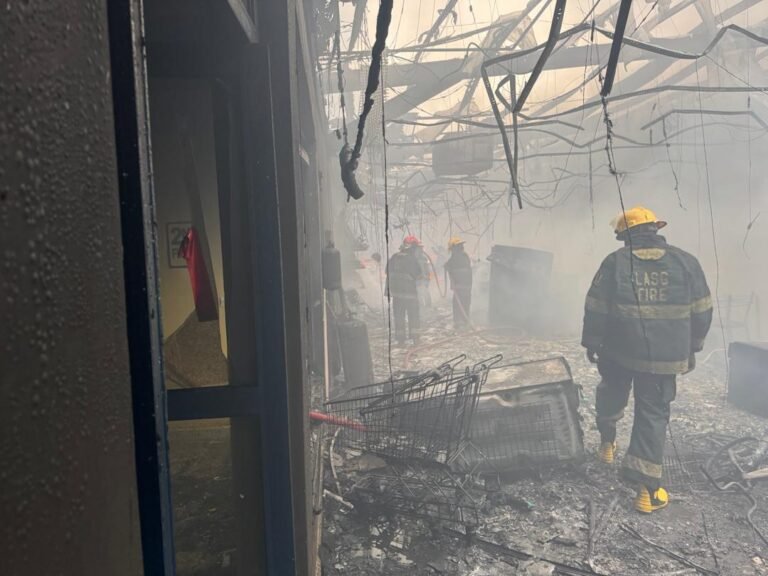 Firefighters battle a blaze at the Justrite Superstore in Akowonjo, Lagos, as smoke rises from the building's rooftop.