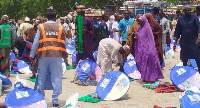 Officials of NEDC and Yobe SEMA distribute relief materials, including bags of rice, blankets and mosquito nets, to windstorm victims in Gashua, Yobe State.