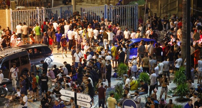 Migrants gather near the border fence between Morocco and Spain's Ceuta enclave during an overnight mass crossing.