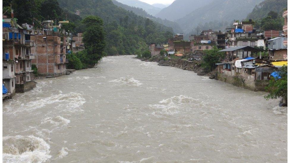 Floodwaters and mud sweep through a Nepalese community near the Tibet border after a deadly flash flood.