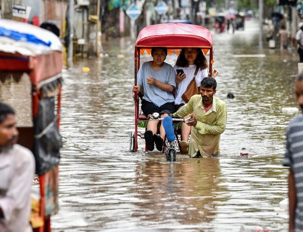Rescue workers evacuate residents by inflatable boats through floodwaters in Assam, India, after deadly monsoon rains caused widespread flooding and landslides.