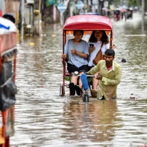 Rescue workers evacuate residents by inflatable boats through floodwaters in Assam, India, after deadly monsoon rains caused widespread flooding and landslides.
