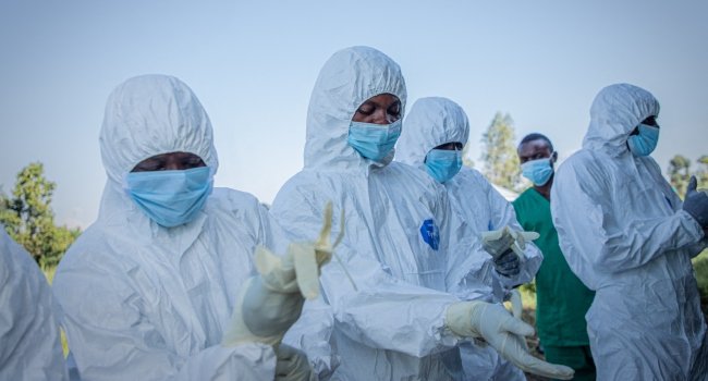 Ebola response volunteers in protective equipment prepare to recover a suspected Ebola victim in Bunia, DR Congo.