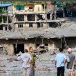 Rescue workers inspect mud-covered homes after deadly flash floods and a glacial collapse in Nepal's Nuwakot district.