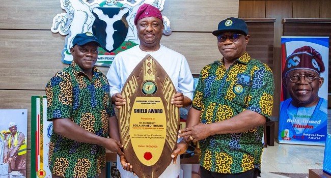 Festus Keyamo displays the NCSU Shield Award presented to President Bola Tinubu for workers’ welfare in Abuja.