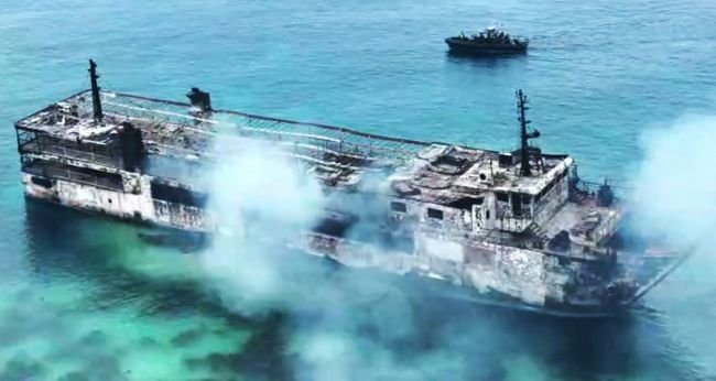 Burnt ferry after a fire off Palawan in the Philippines, with rescue efforts ongoing