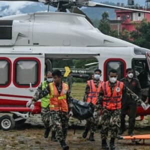 Army personnel carry a flash flood victim's body outside a temporary relief camp in Nuwakot, Nepal.