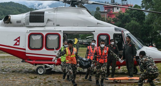 Army personnel carry a flash flood victim's body outside a temporary relief camp in Nuwakot, Nepal.