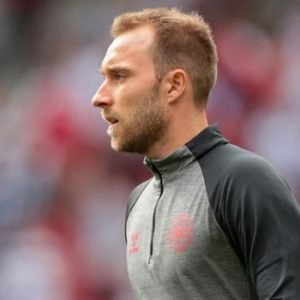 Christian Eriksen lying on the pitch during Denmark vs Ukraine friendly as medical staff and teammates surround him while treatment is administered and play is halted.