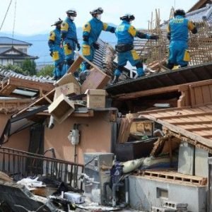 Rescue workers search through the collapsed Aeon shopping mall in Kumamoto after a powerful earthquake as emergency operations continue.