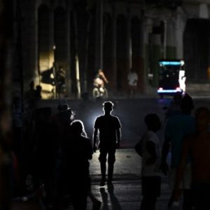 People walking through darkened streets in Havana during widespread blackout as Cuba faces severe fuel shortages.