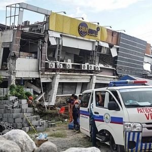 Rescue workers search through collapsed buildings in General Santos City after a powerful 7.8-magnitude earthquake struck southern Philippines, killing at least 15 people and triggering tsunami warnings.