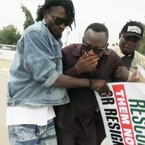 Protesters dispersing in Abuja after police fired teargas during a Democracy Day demonstration, with Omoyele Sowore seen receiving assistance from others.