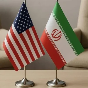 Iran and US flags representing escalating tensions over the Strait of Hormuz.