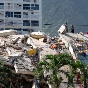 Rescue workers search through the rubble of a collapsed building in La Guaira, Venezuela, following the devastating June 2026 earthquakes.