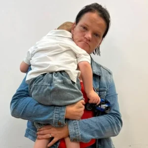 NDLEA operatives escort a South African woman arrested at Abuja airport over the alleged smuggling of 5.75kg of heroin while travelling with her young son.