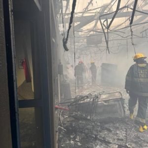 Firefighters battle a blaze at the Justrite Superstore in Akowonjo, Lagos, as smoke rises from the building's rooftop.