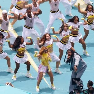 Shakira performing on stage during the 2026 World Cup opening ceremony at Estadio Azteca alongside Burna Boy as fireworks light up the stadium.
