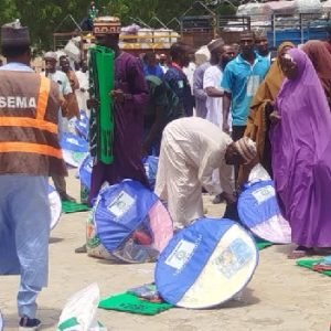 Officials of NEDC and Yobe SEMA distribute relief materials, including bags of rice, blankets and mosquito nets, to windstorm victims in Gashua, Yobe State.