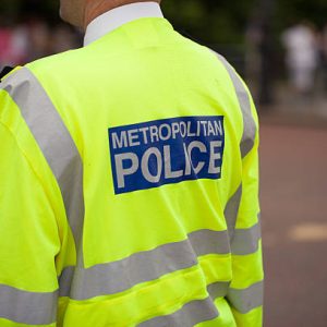 London metropolitan Police officer patrolling crowds on the Mall, London, UK