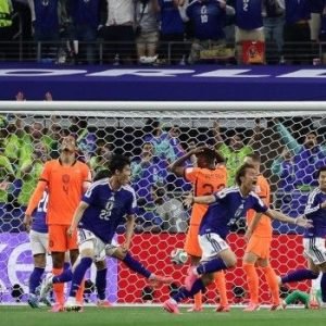 Japan players celebrating a late equaliser against the Netherlands during a 2-2 World Cup Group F match in Texas stadium.