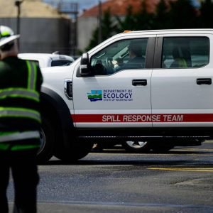 Emergency response vehicles outside the Nippon Dynawave Packaging plant in Longview, Washington, following a fatal chemical tank implosion that killed 11 workers.